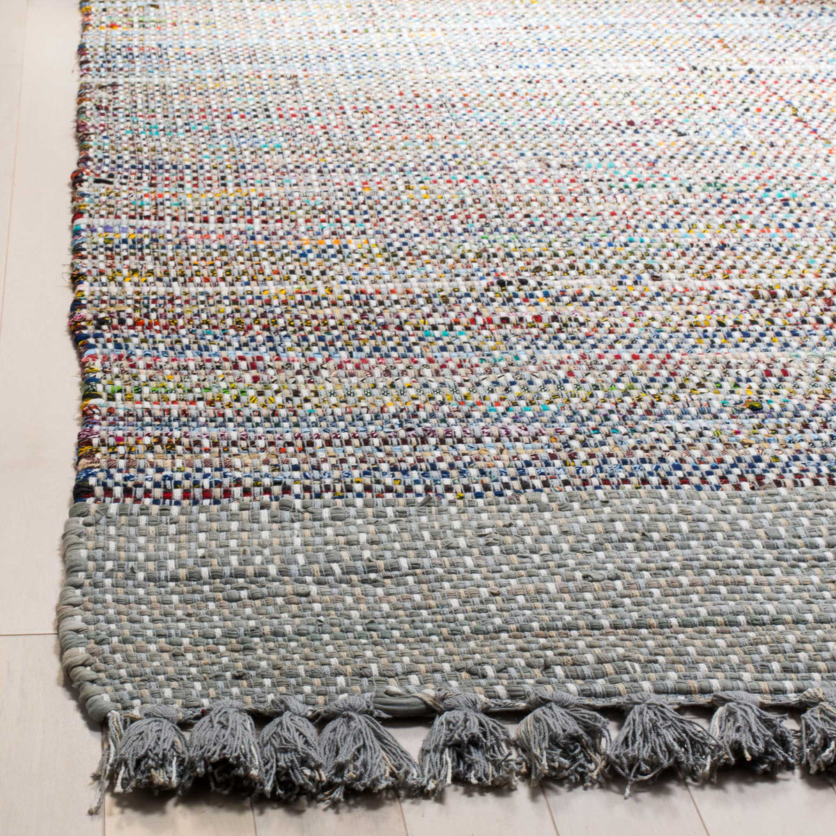 Tasseled gray cotton edging frames a dense weave of colorful textured yarns