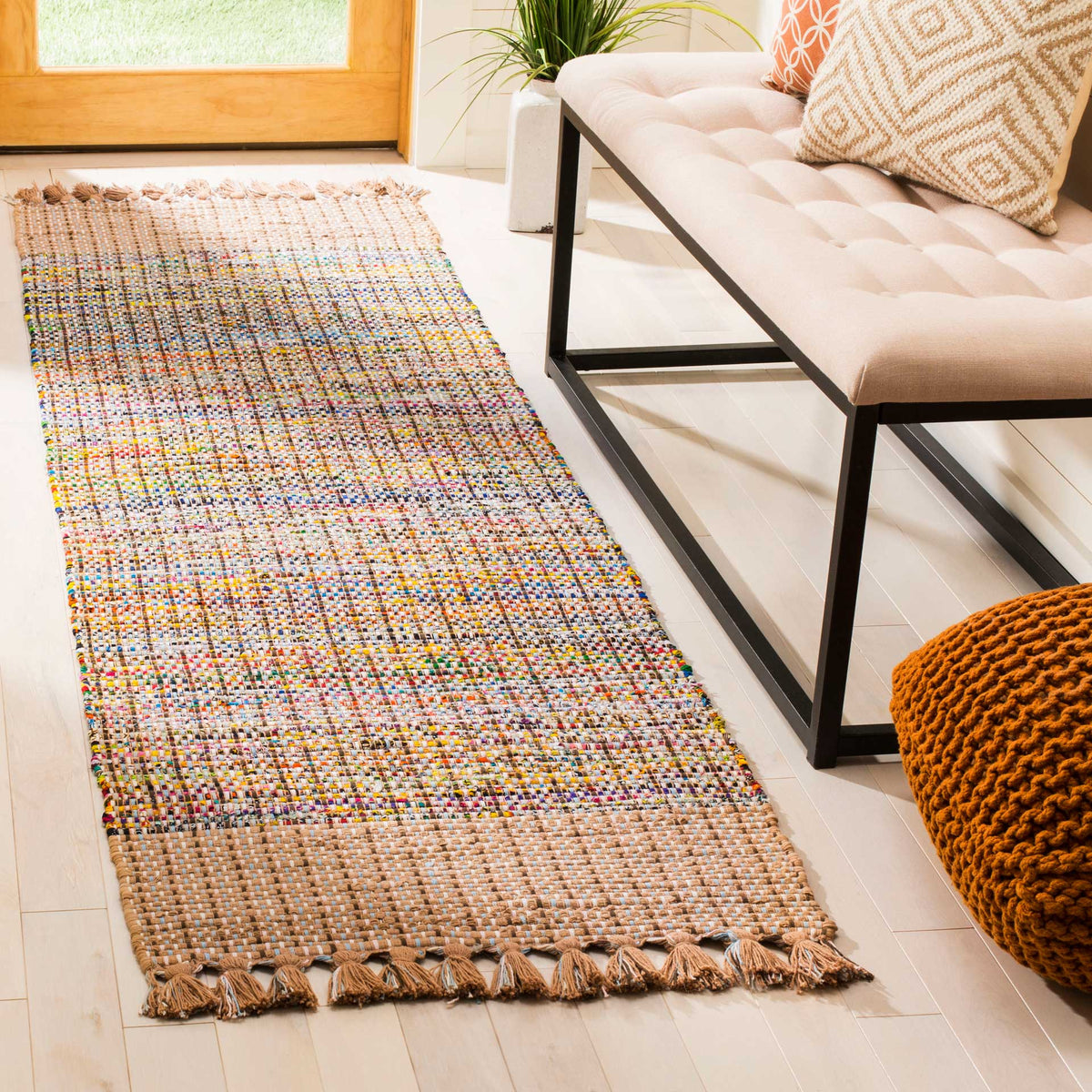 A beige-fringed runner brings a lively multicolored weave and warm texture to an entryway