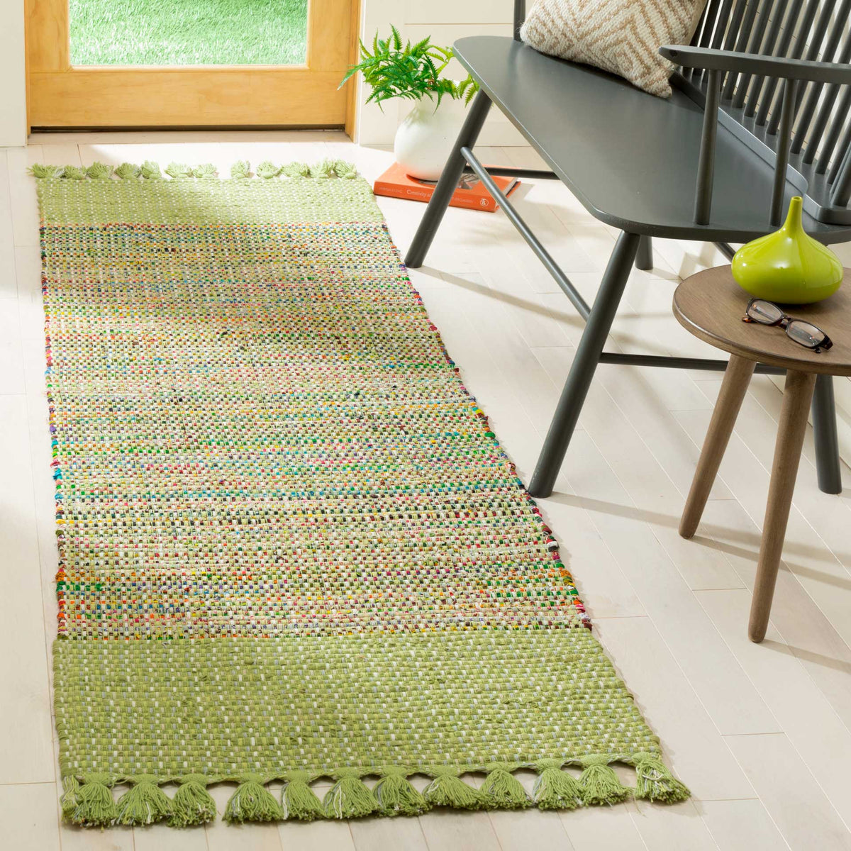 Fresh green end panels anchor a lively multicolored weave along a sunlit entryway