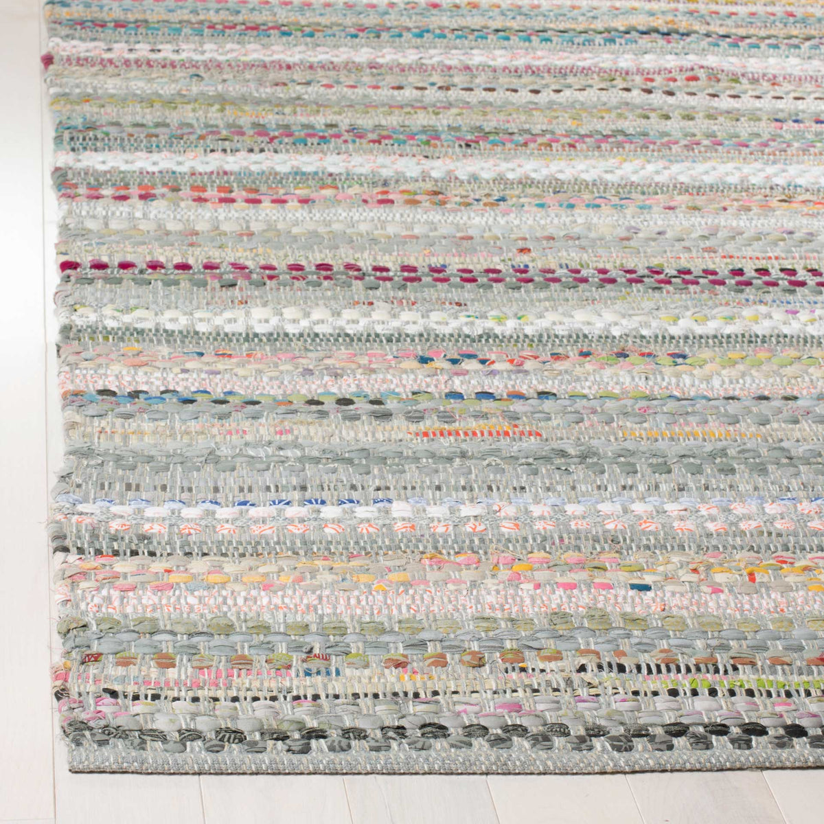 Layered gray cotton yarns and colorful flecks form a tactile weave at this rug's finished corner.