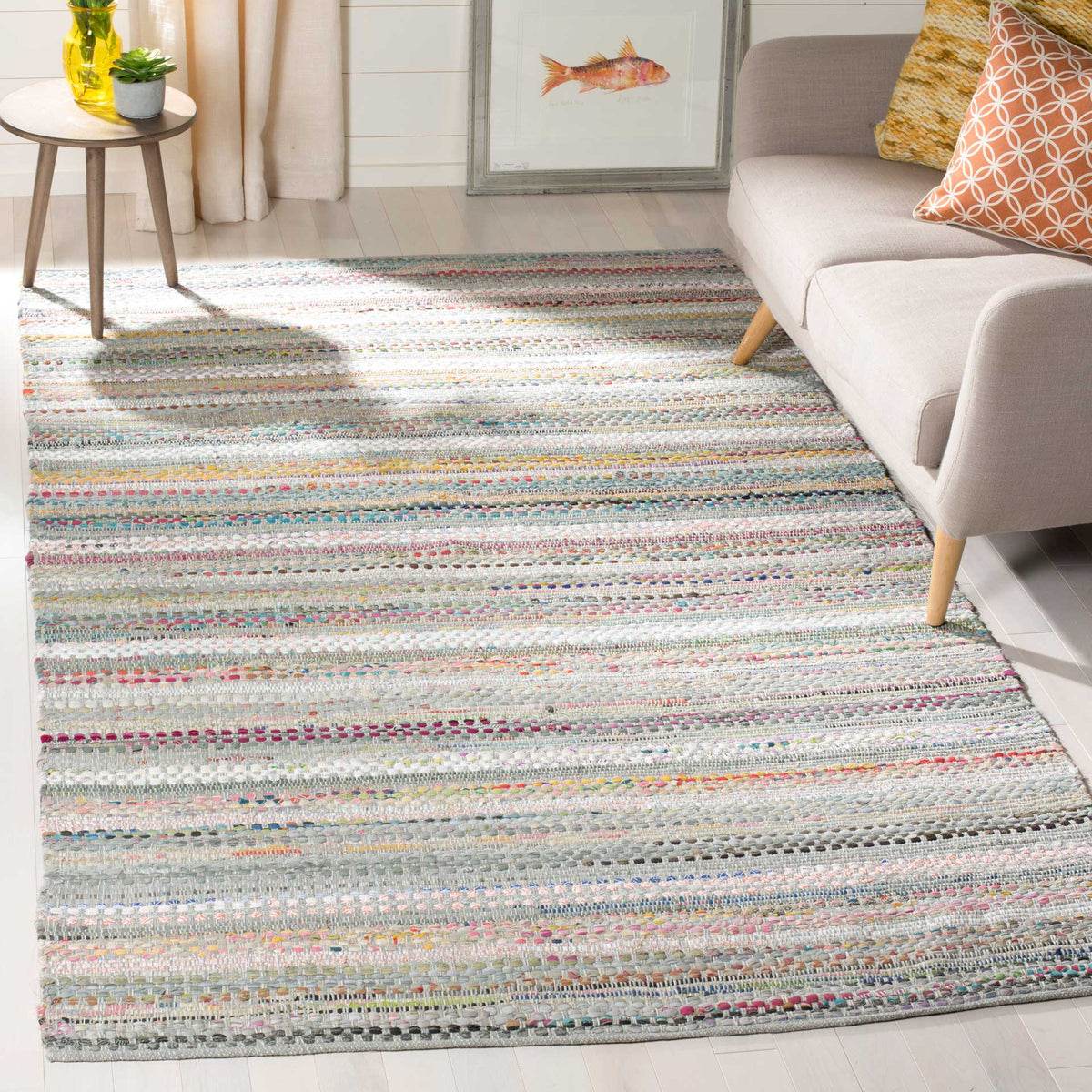 Soft gray stripes with scattered color add handwoven warmth to a relaxed living area.