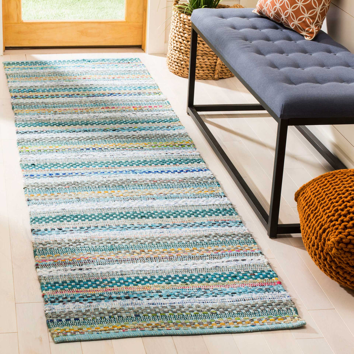 Textured aqua and blue stripes add a fresh accent beside an entryway bench