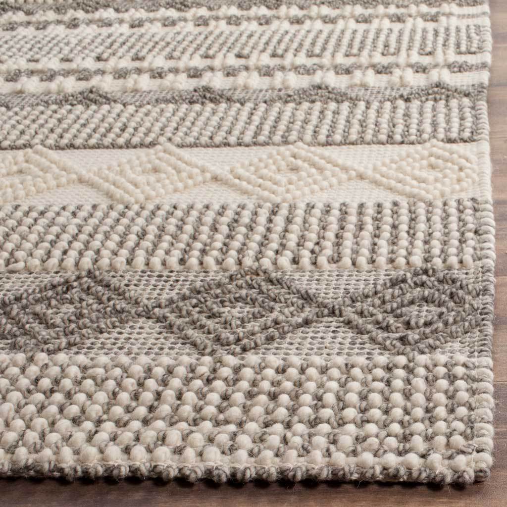 Chunky ivory loops frame raised gray diamonds on this richly textured rug.