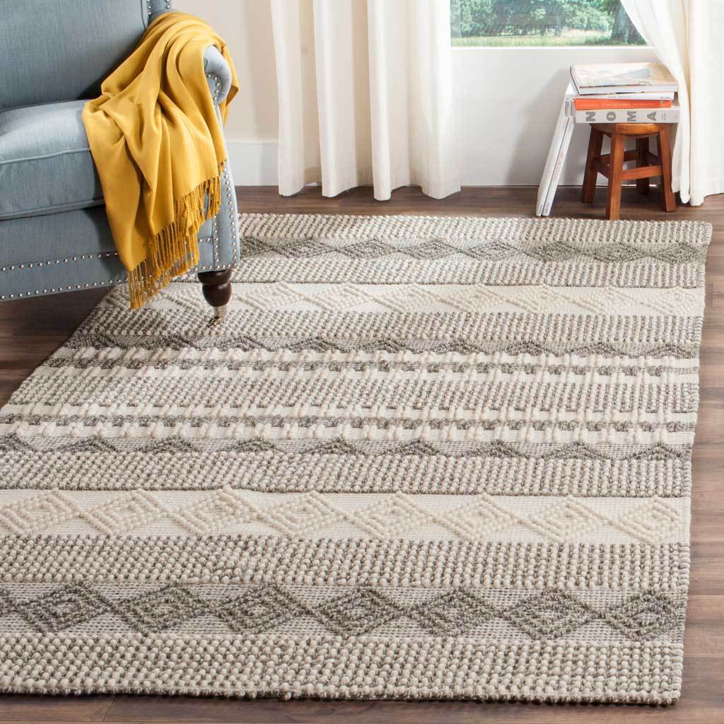Gray diamond bands and ivory stripes add warmth and texture beneath living room furniture.