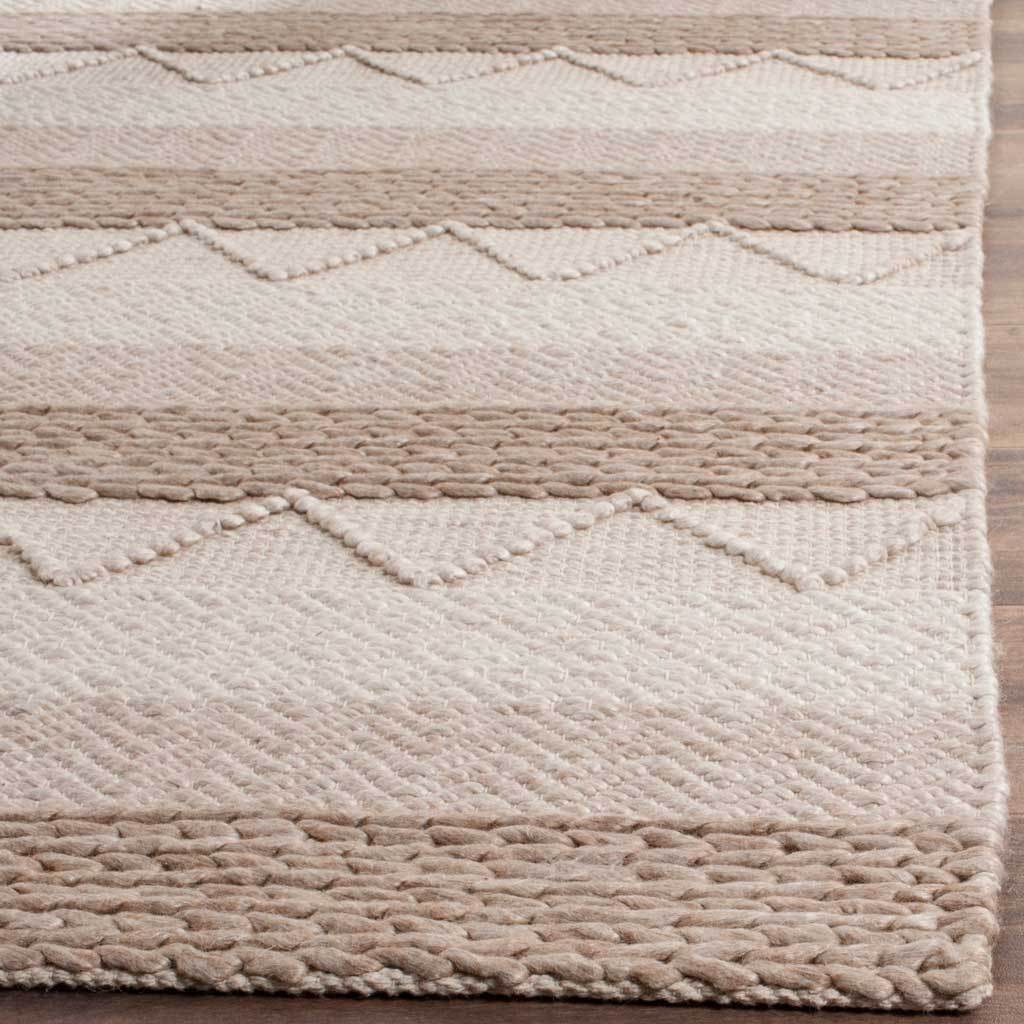 Raised geometric stitching and chunky woven edges enrich the rug's soft beige and ivory texture.