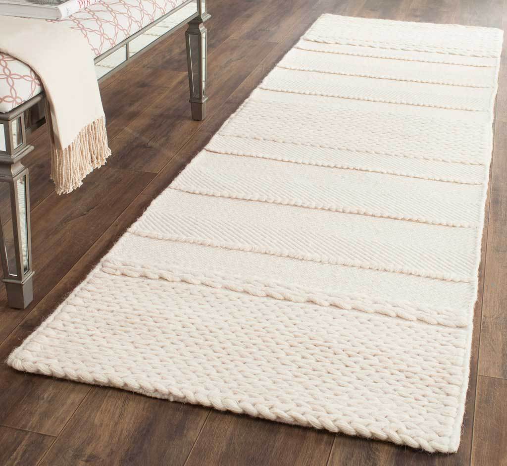 Soft natural runner with textured horizontal bands brings warmth to a wood floor