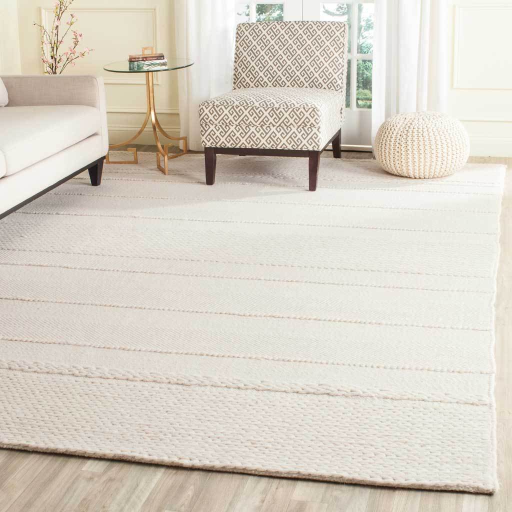 An ivory rug layers understated stripes and cozy woven texture beneath living room furniture.