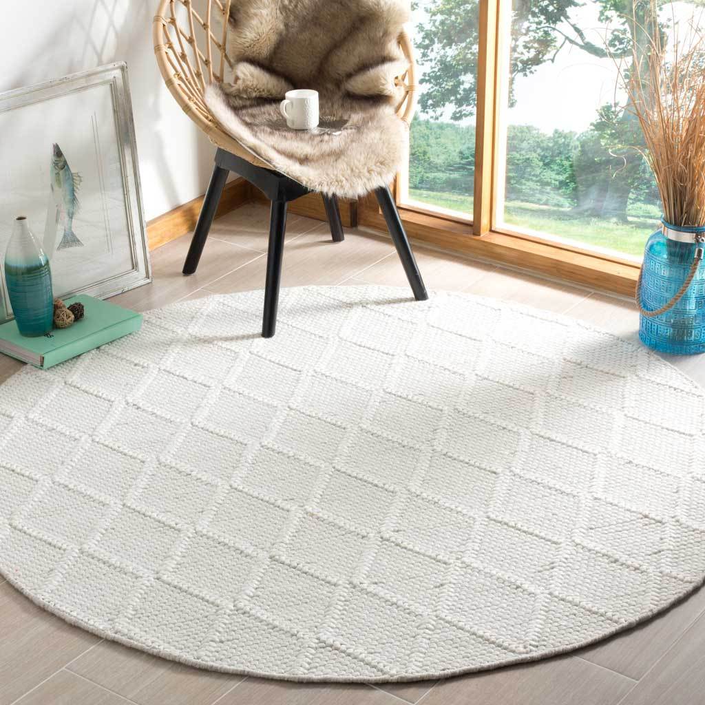 Ivory round rug with a raised diamond lattice that adds texture beneath a lounge chair