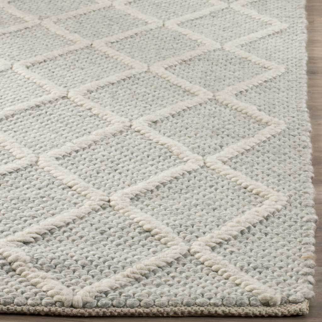 Raised ivory lattice and a neatly finished edge accent the rug's textured silver weave.
