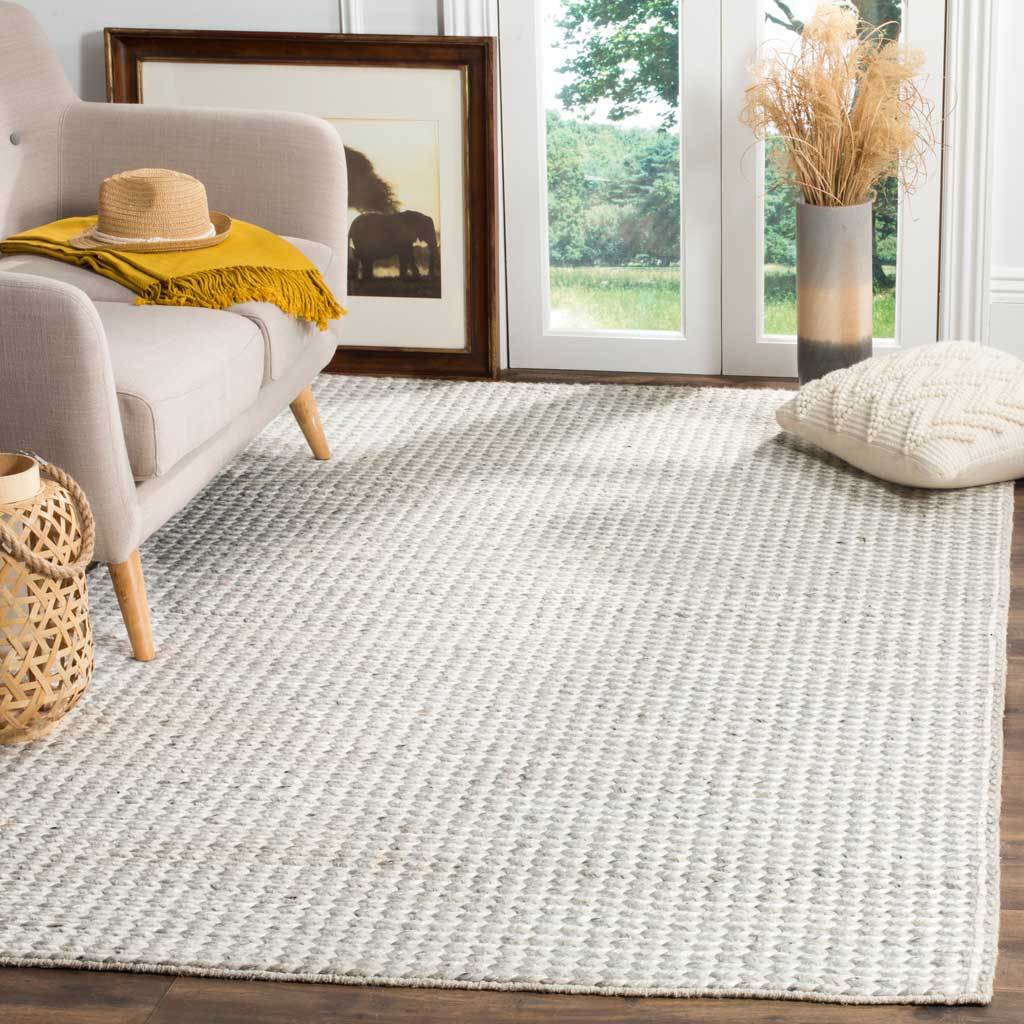 An ivory and silver woven rug brightens a relaxed seating area with its soft, tonal texture.