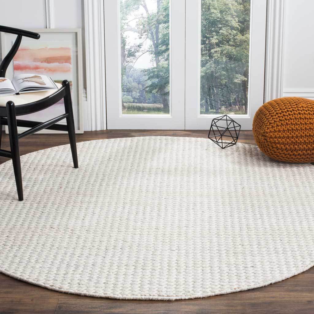 Soft ivory and silver round rug adds woven warmth to a bright seating area