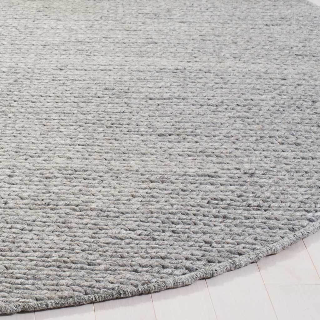 Tightly woven steel-gray fibers create rich texture along the rug's curved edge