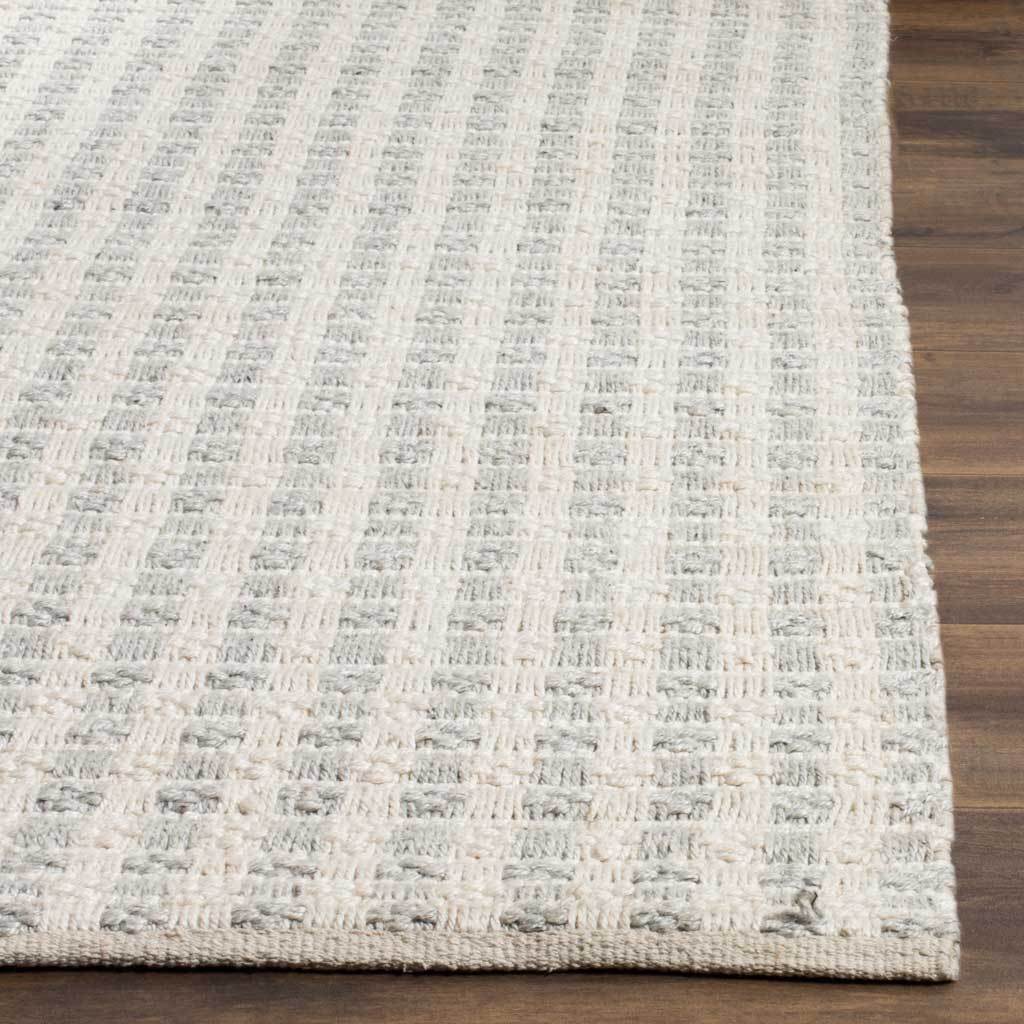 A neatly finished edge frames the rug's soft gray and ivory stripes and tactile weave