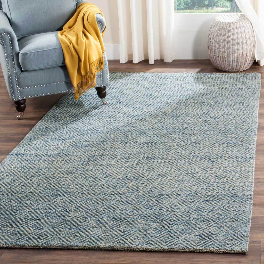 A blue woven rug brings inviting texture and relaxed color to a bright seating area.