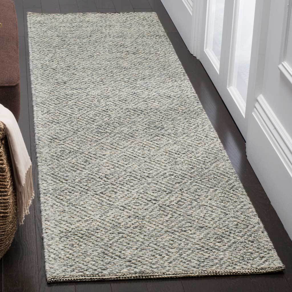A muted camel and gray runner adds understated warmth and texture to a hallway