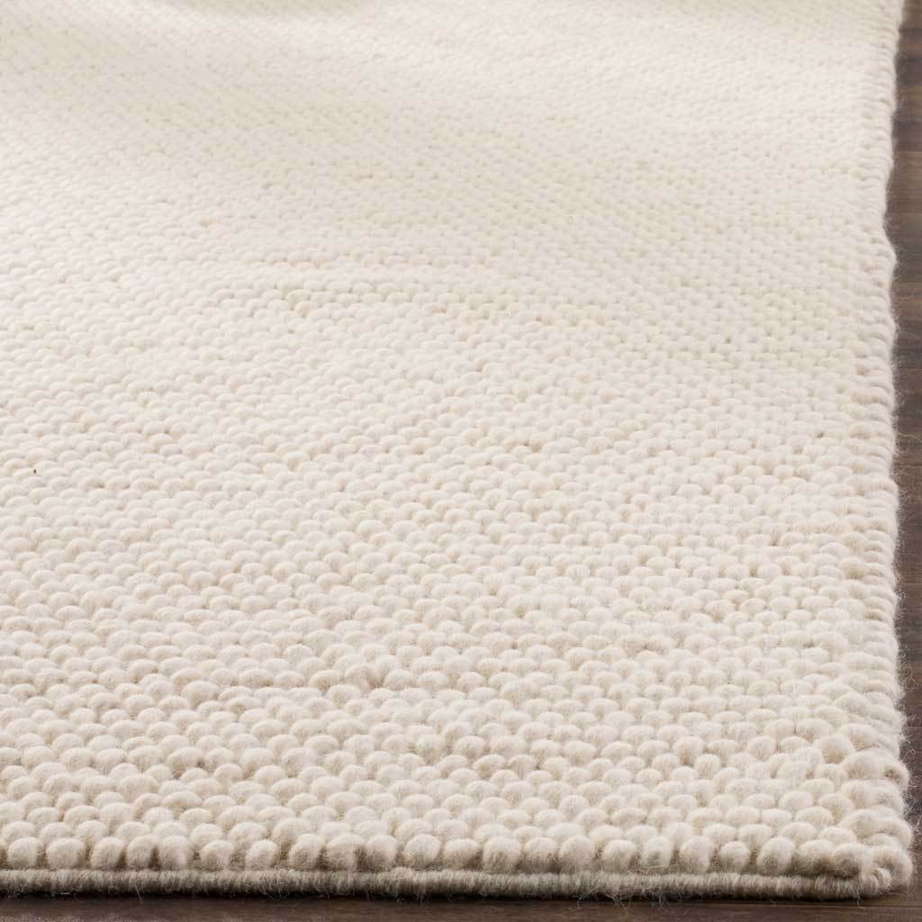 Ivory wool-cotton loops form a cushioned surface with a neatly finished edge