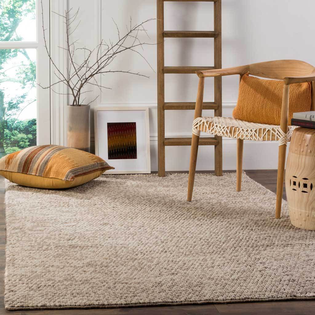 A beige, pebble-textured rug brings warmth and comfort to a relaxed seating area