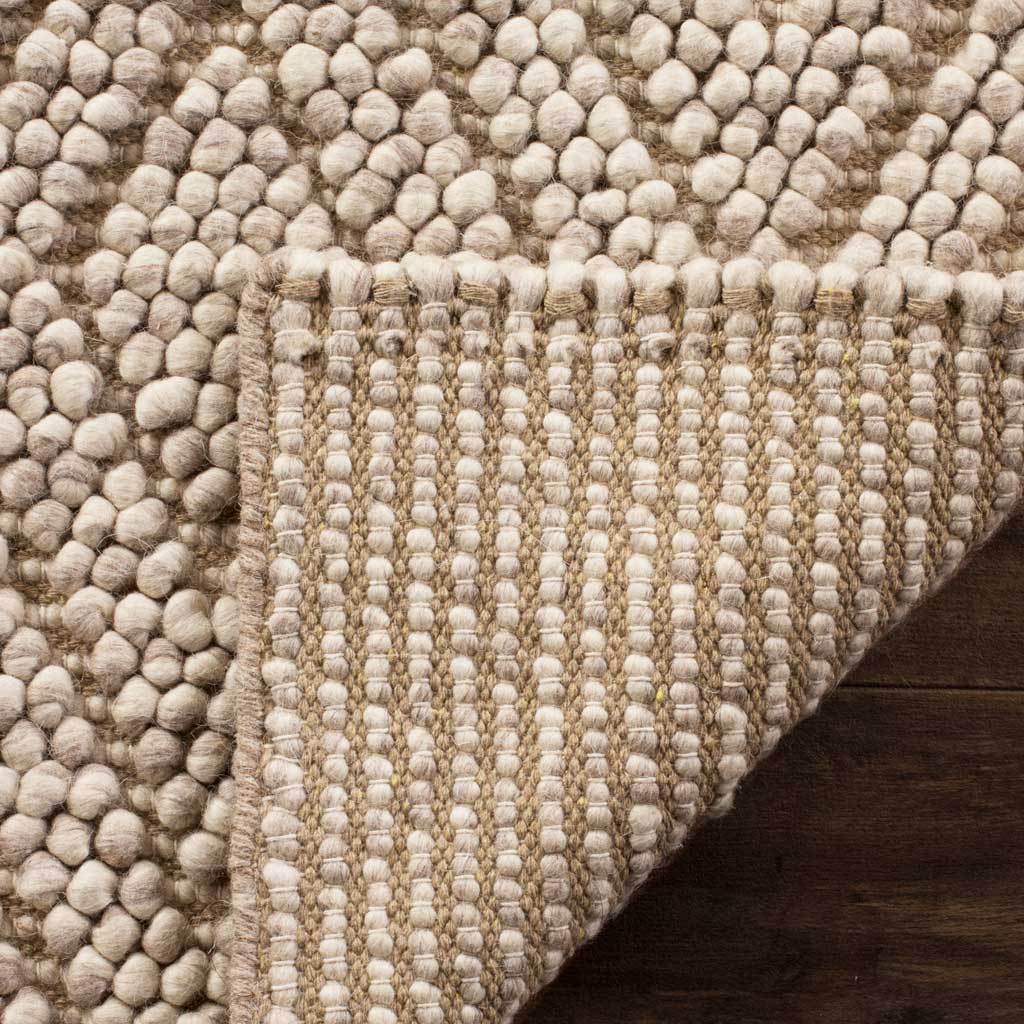 Folded beige rug reveals a tightly woven backing beneath its textured diamond surface