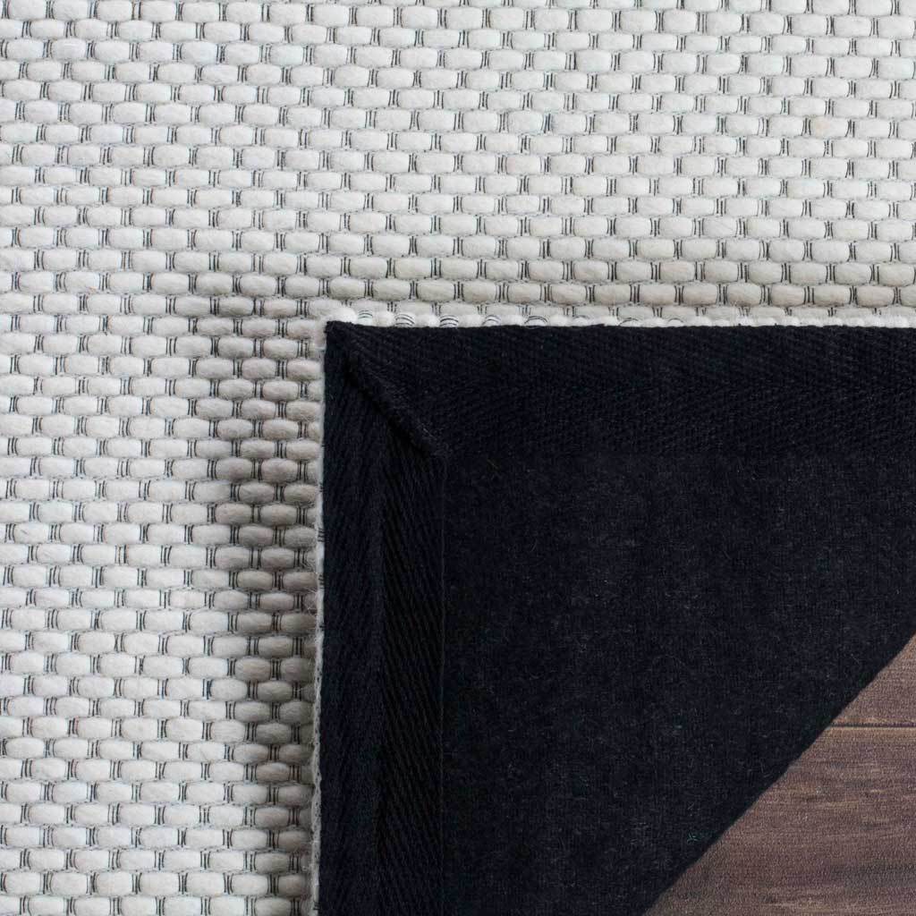 Ivory woven loops sit above a dark fabric backing visible at the folded corner.