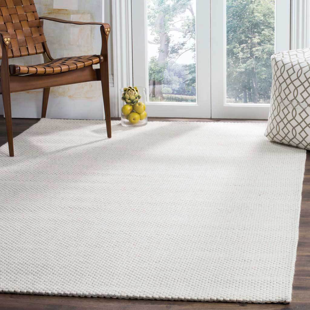 A creamy ivory rug brings airy warmth and woven texture to a sunlit space.