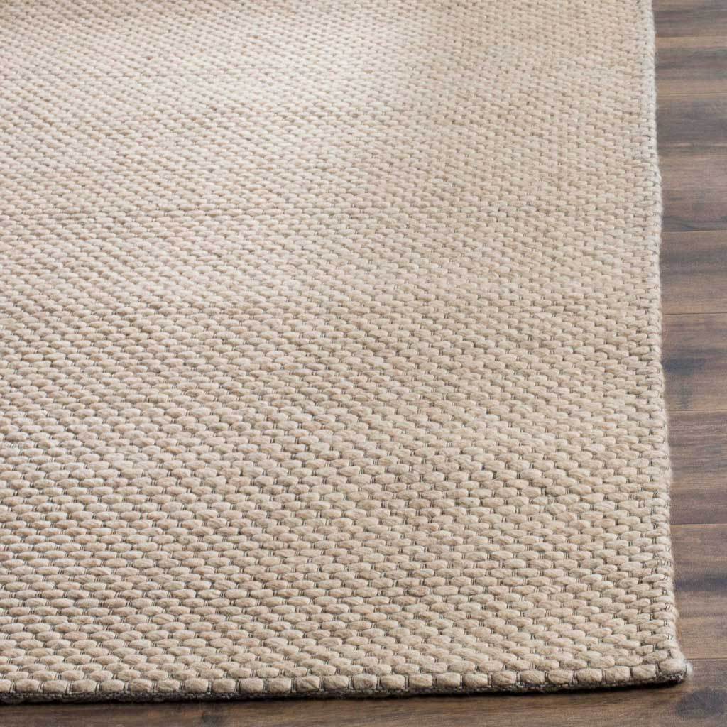 Thick beige loops define a tactile weave and a neatly finished rug corner.