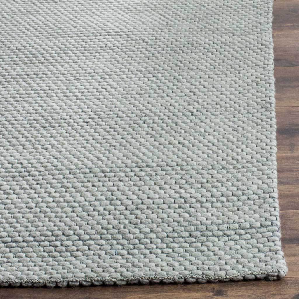 Chunky gray loops give the rug a tactile texture and neatly finished corner.