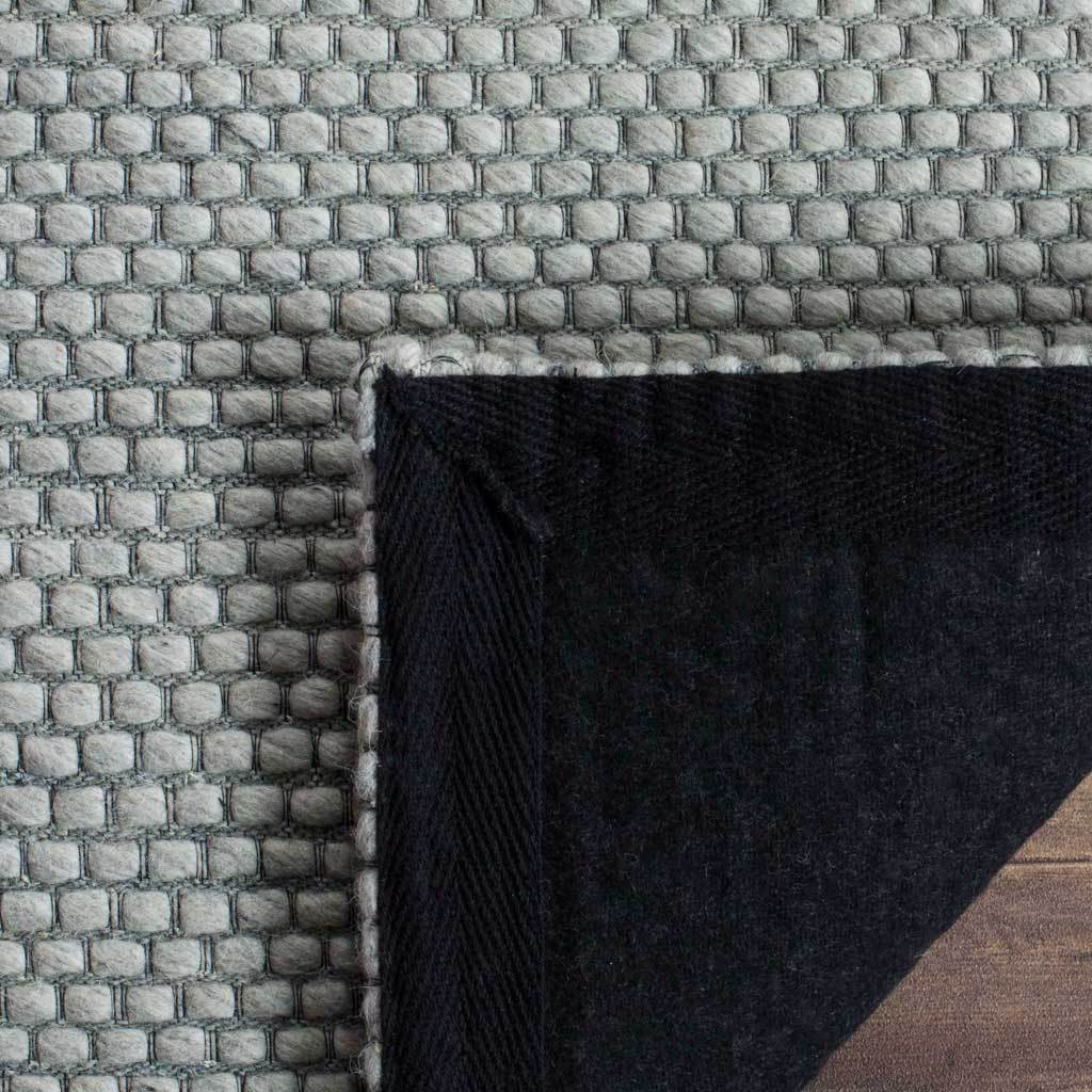 A folded edge reveals a dark fabric backing beneath the gray woven surface.