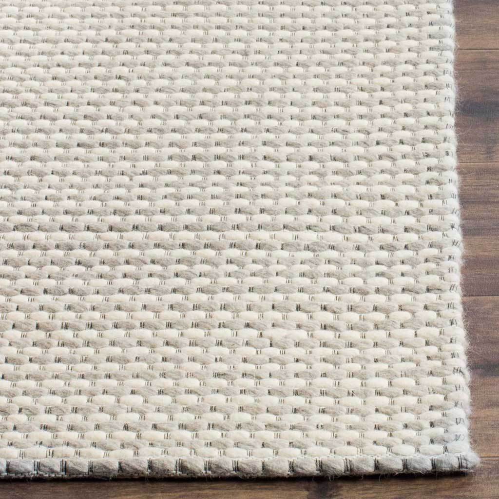 Ivory loops flecked with silver give the rug a tactile, neatly finished corner.