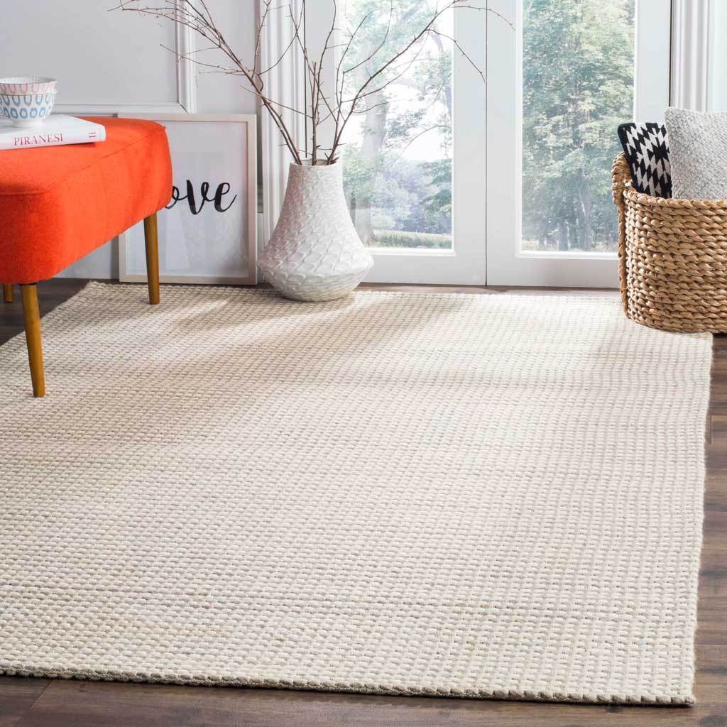 A soft silver-and-ivory rug brightens the floor with understated woven texture.