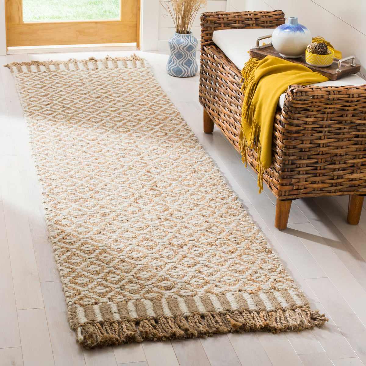 A soft ivory diamond lattice and generous jute tassels add artisanal warmth to an entryway.