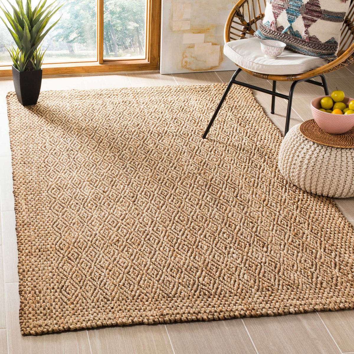 Earth-toned jute rug with woven diamonds warms a cozy chair-and-pouf arrangement.