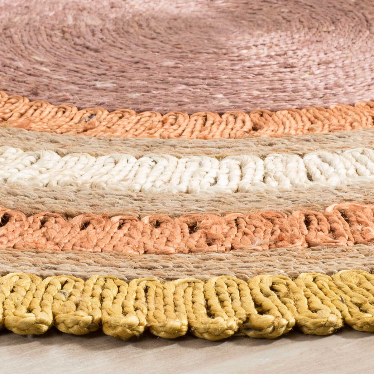 Golden, ivory, and peach loops create raised rings around a tightly braided mauve center.