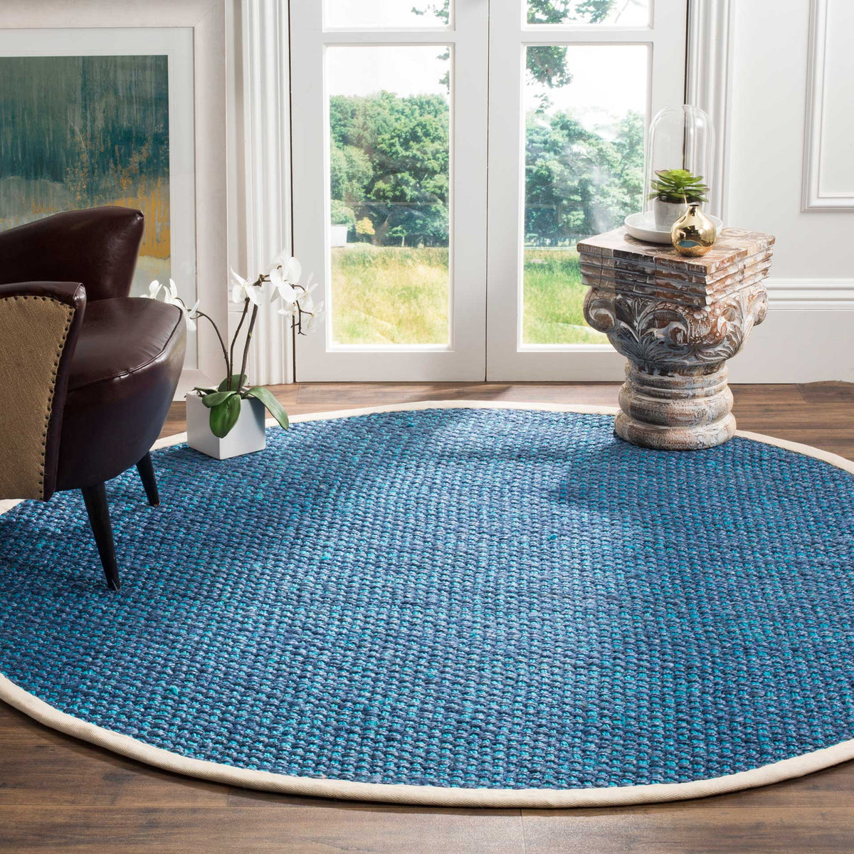 Rich blue jute texture and a pale fabric border enliven this round rug.