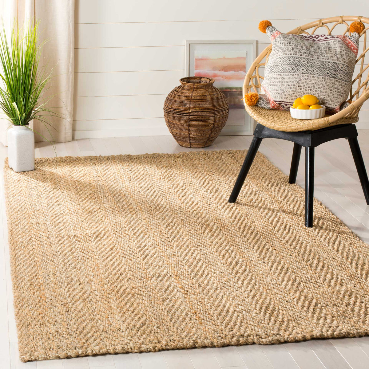 Natural herringbone jute rug adds inviting texture beneath a woven accent chair.