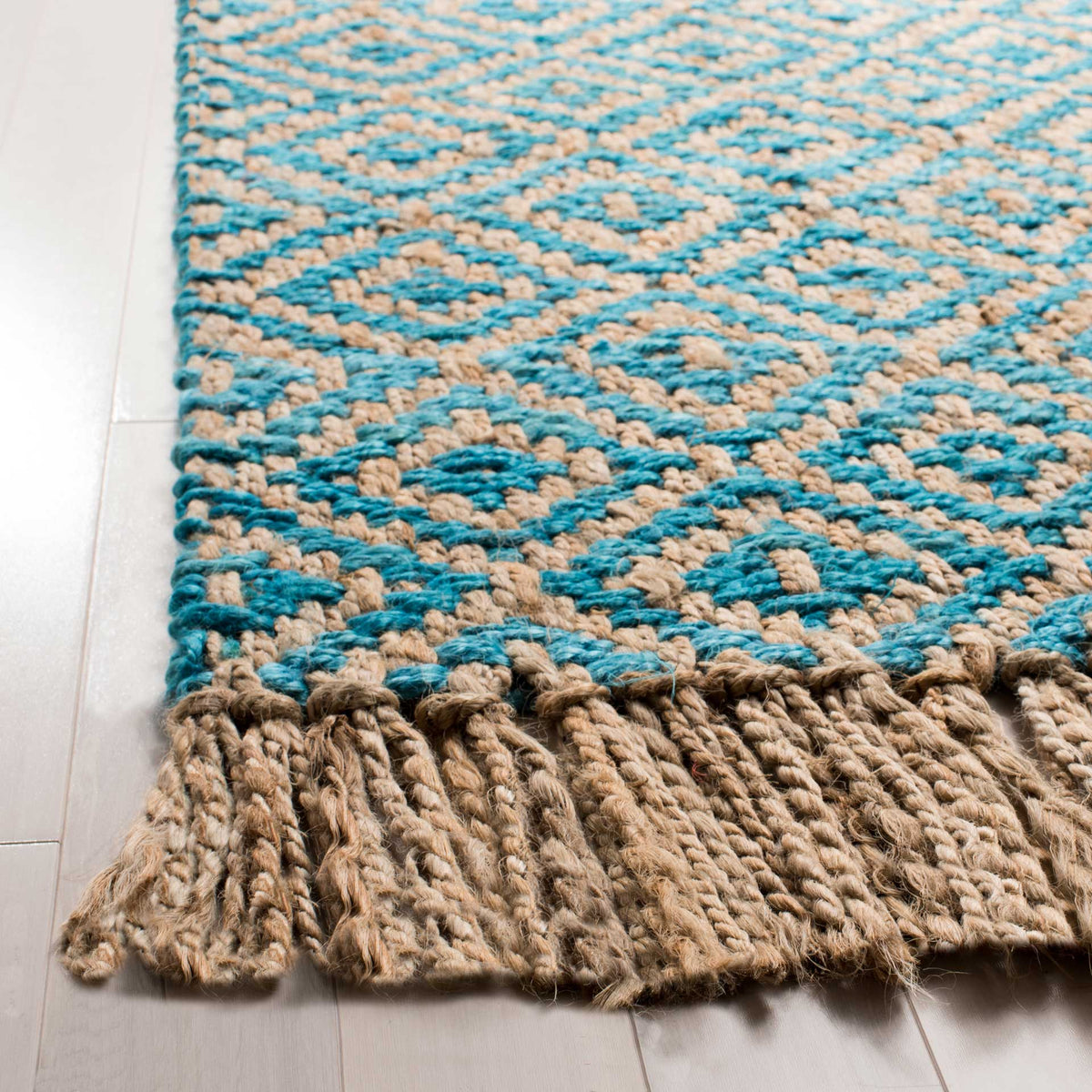 Turquoise jute diamonds contrast with tan yarns above a thick, twisted fringe.
