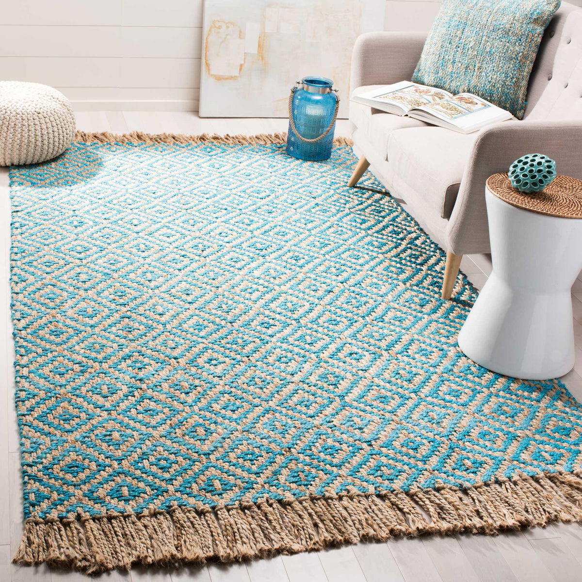 A turquoise diamond jute rug adds lively color and natural fringe beside a pale sofa.