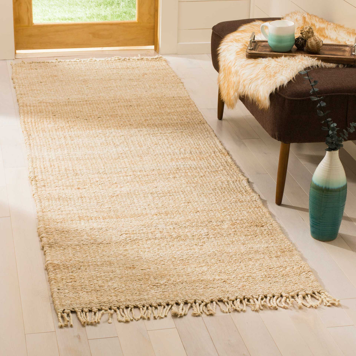 Ivory woven jute and relaxed fringe bring airy texture to a sunlit entryway.