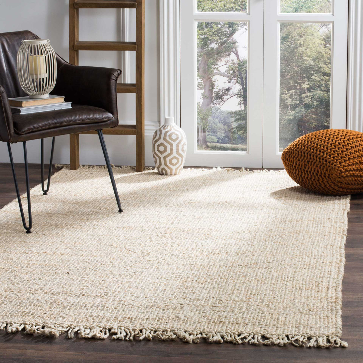 An ivory jute rug brightens the floor with soft tonal texture and relaxed fringe.