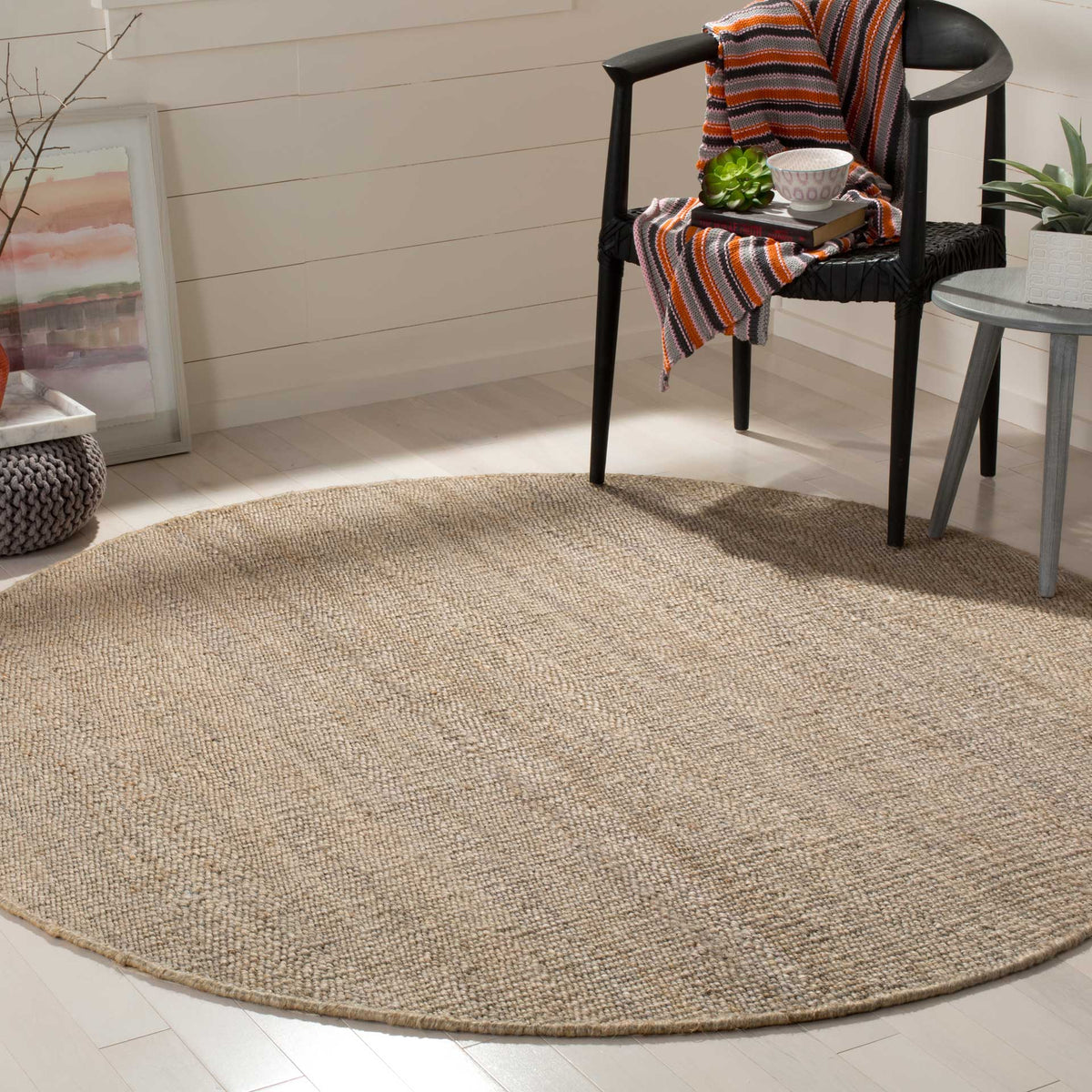 A neutral gray jute surface brings quiet texture and warmth to this understated round rug.