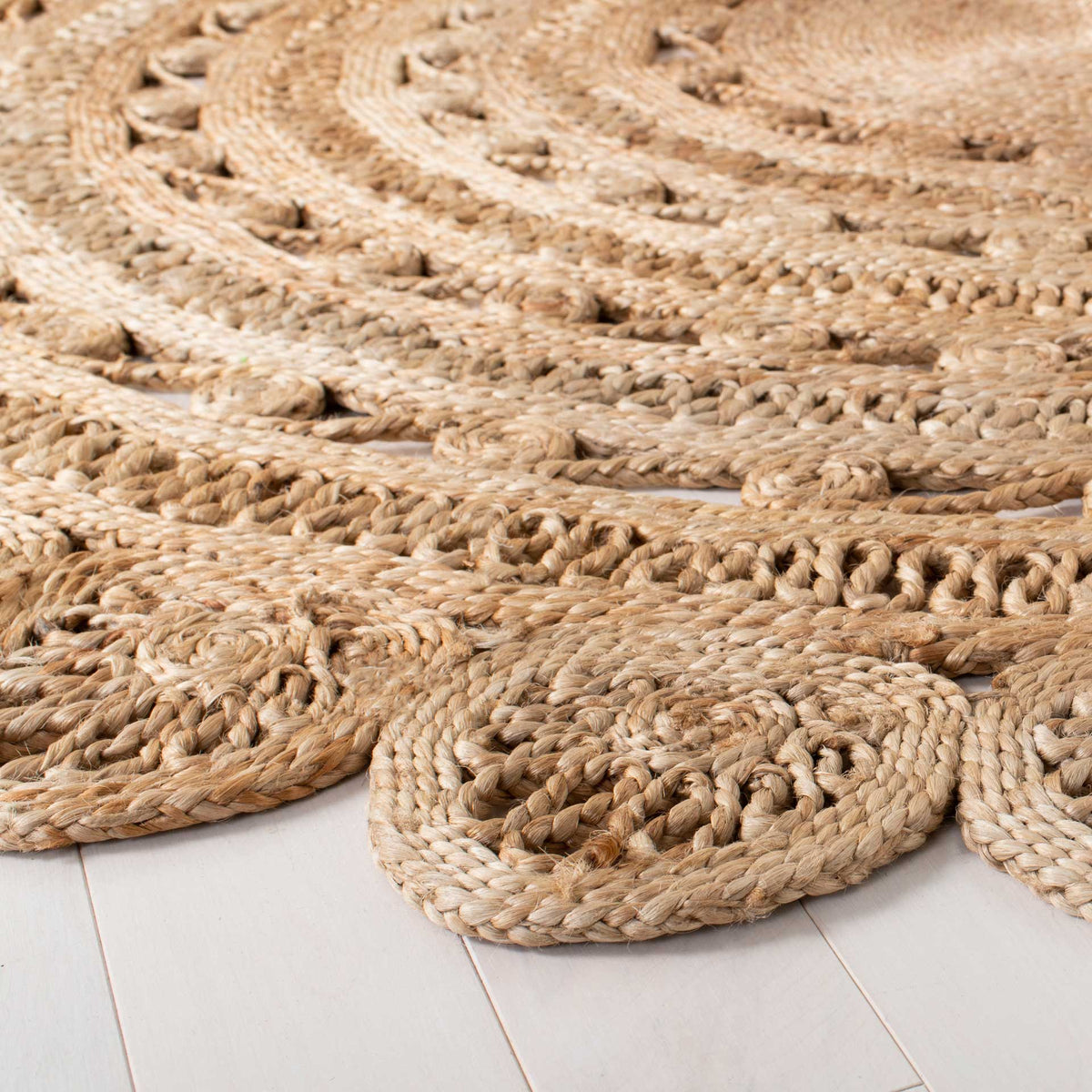 Braided jute spirals and rounded scallops add sculptural texture to the rug's outer edge.