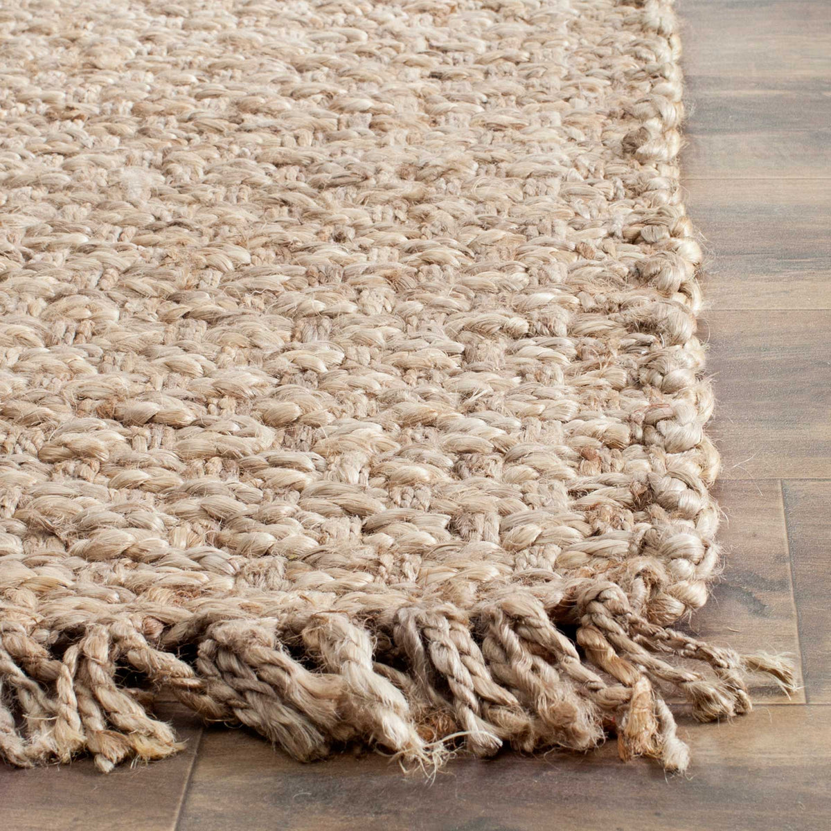 Thick jute loops and twisted fringe highlight the rug's rustic woven edge.