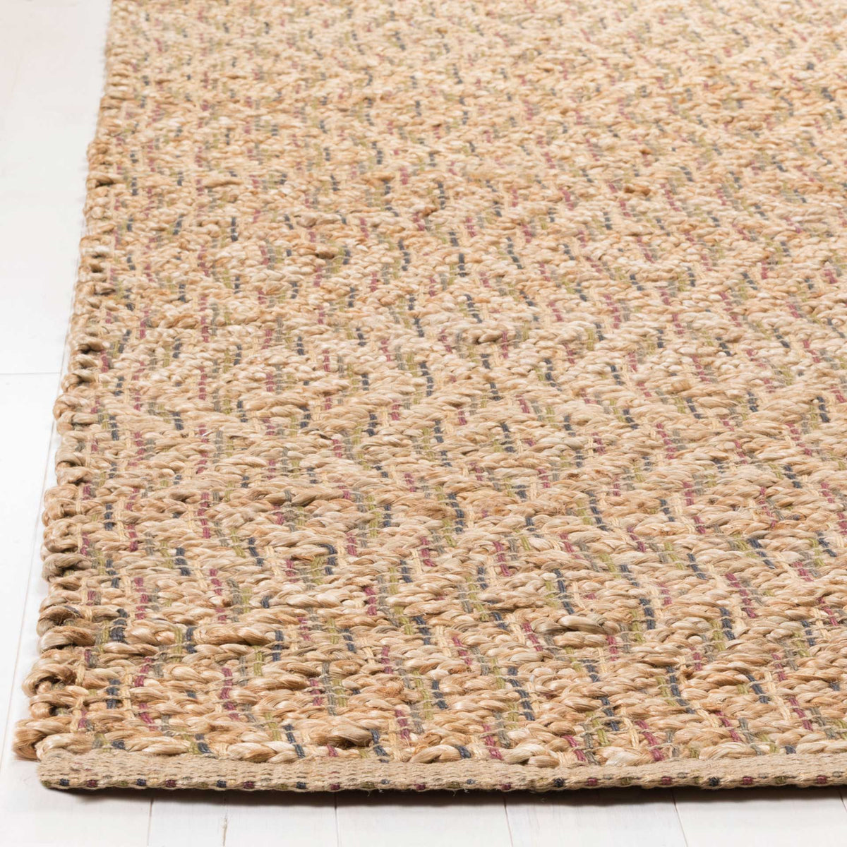 Natural jute fibers weave around subtle red and blue threads at a tidy finished edge.