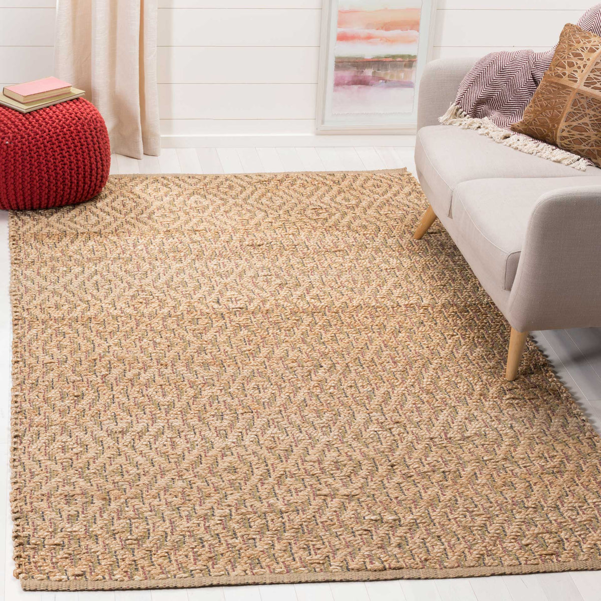 A softly patterned natural jute rug adds earthy texture beside a pale sofa.