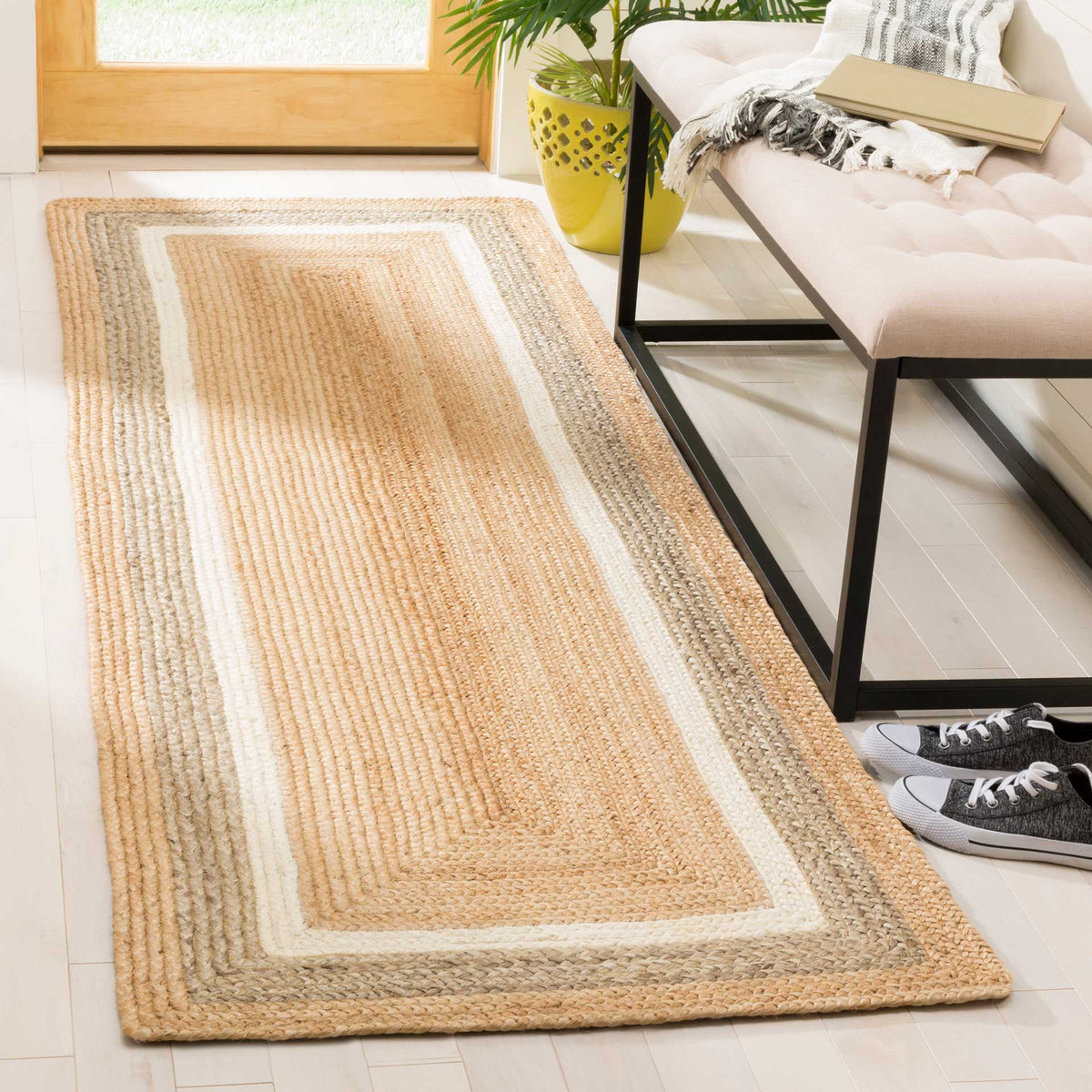 A wide ivory border and soft gray accents frame this natural jute runner in an airy entryway.