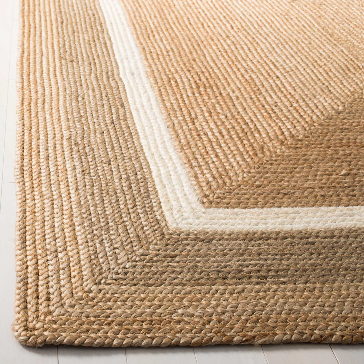 Ivory and gray woven bands outline the tan rug's rounded, textured corner.
