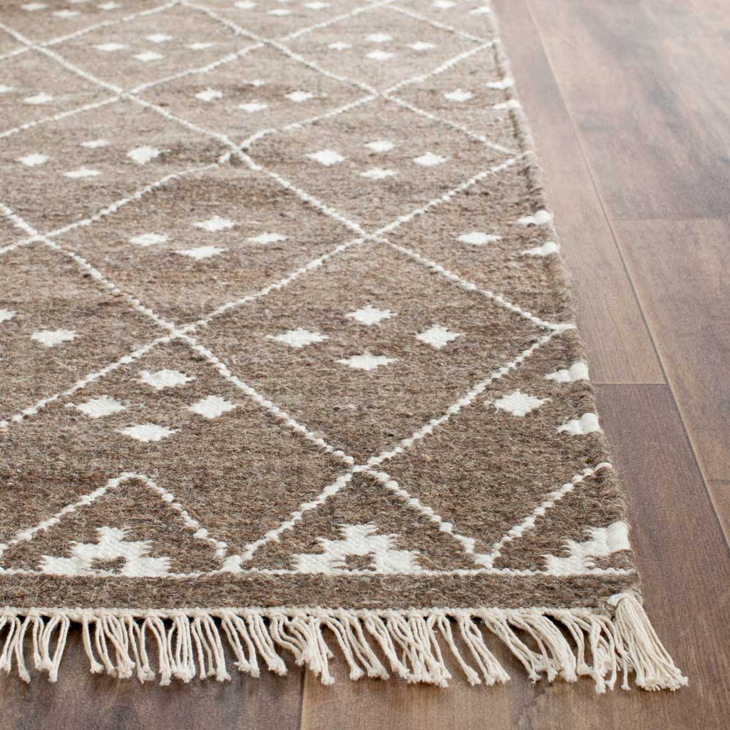 Ivory lattice lines and tiny motifs meet a delicate fringed edge on warm brown weave.