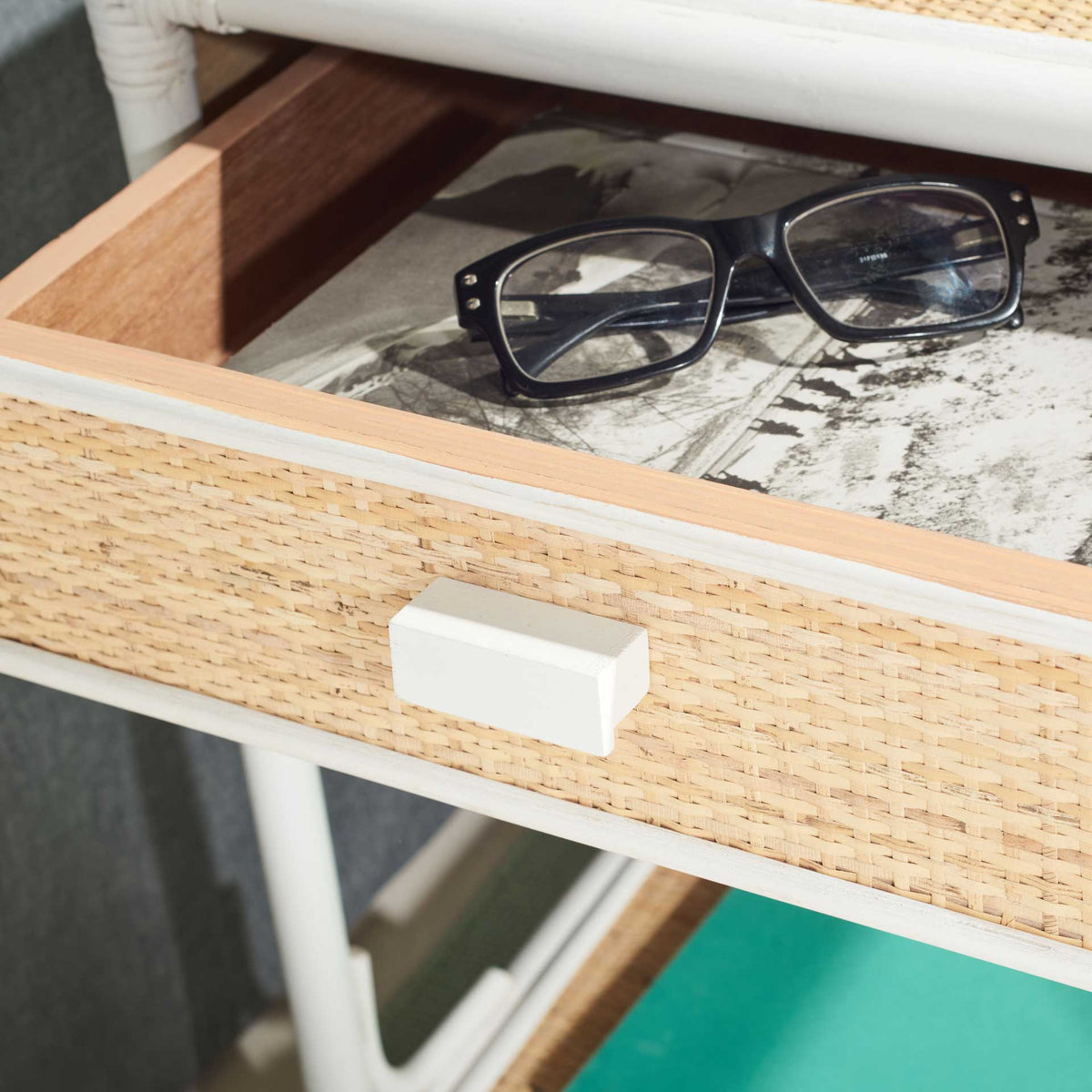 An open woven-front drawer keeps glasses and reading material handy at the bedside
