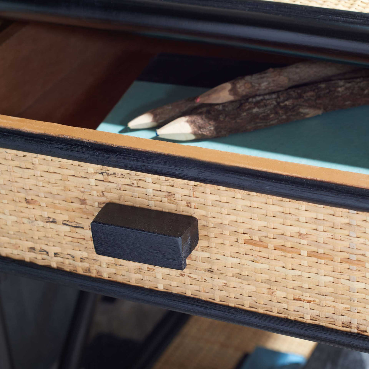 An open cane-front drawer offers wood-lined storage for small bedside essentials
