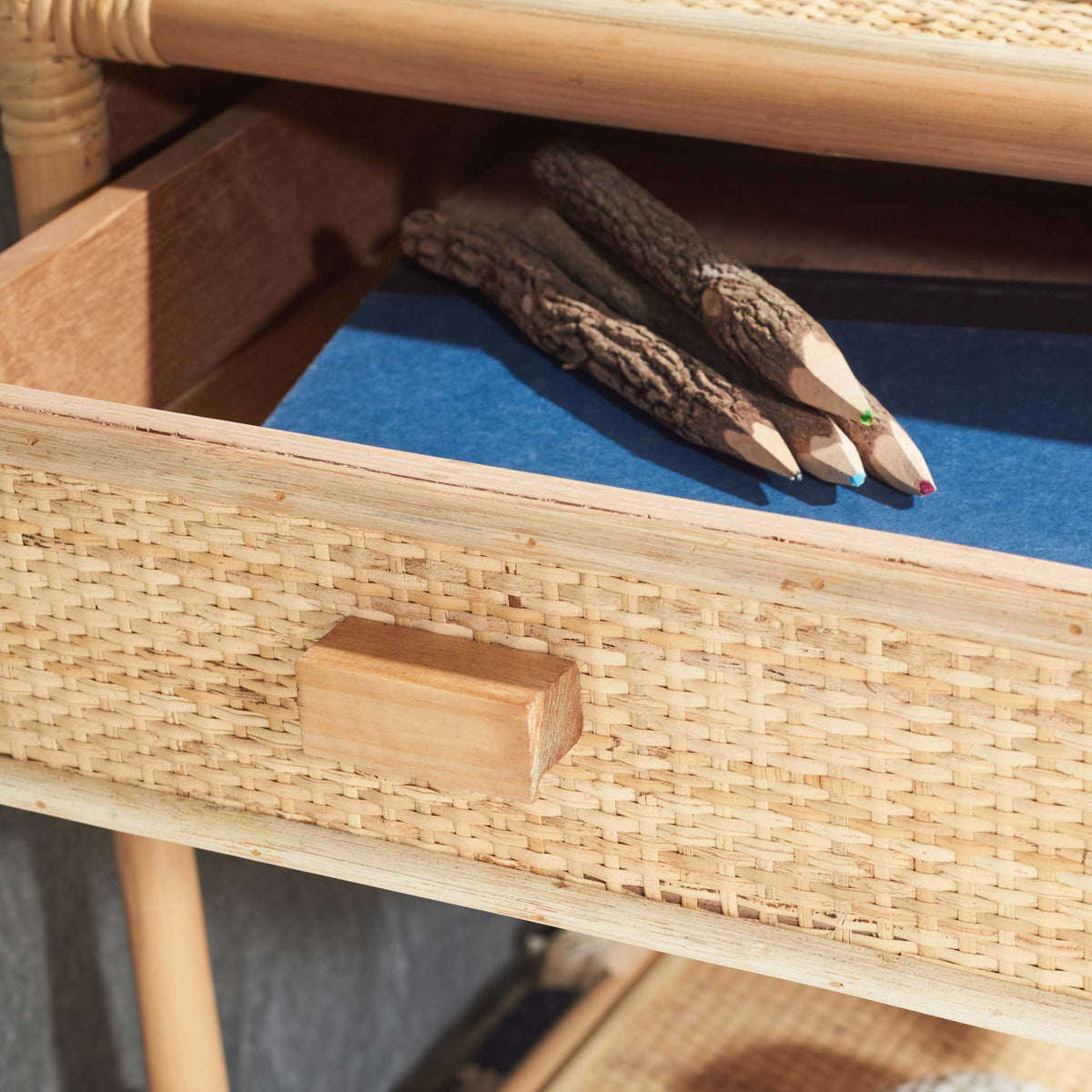 Open cane-front drawer keeps pencils and other bedside items neatly tucked away
