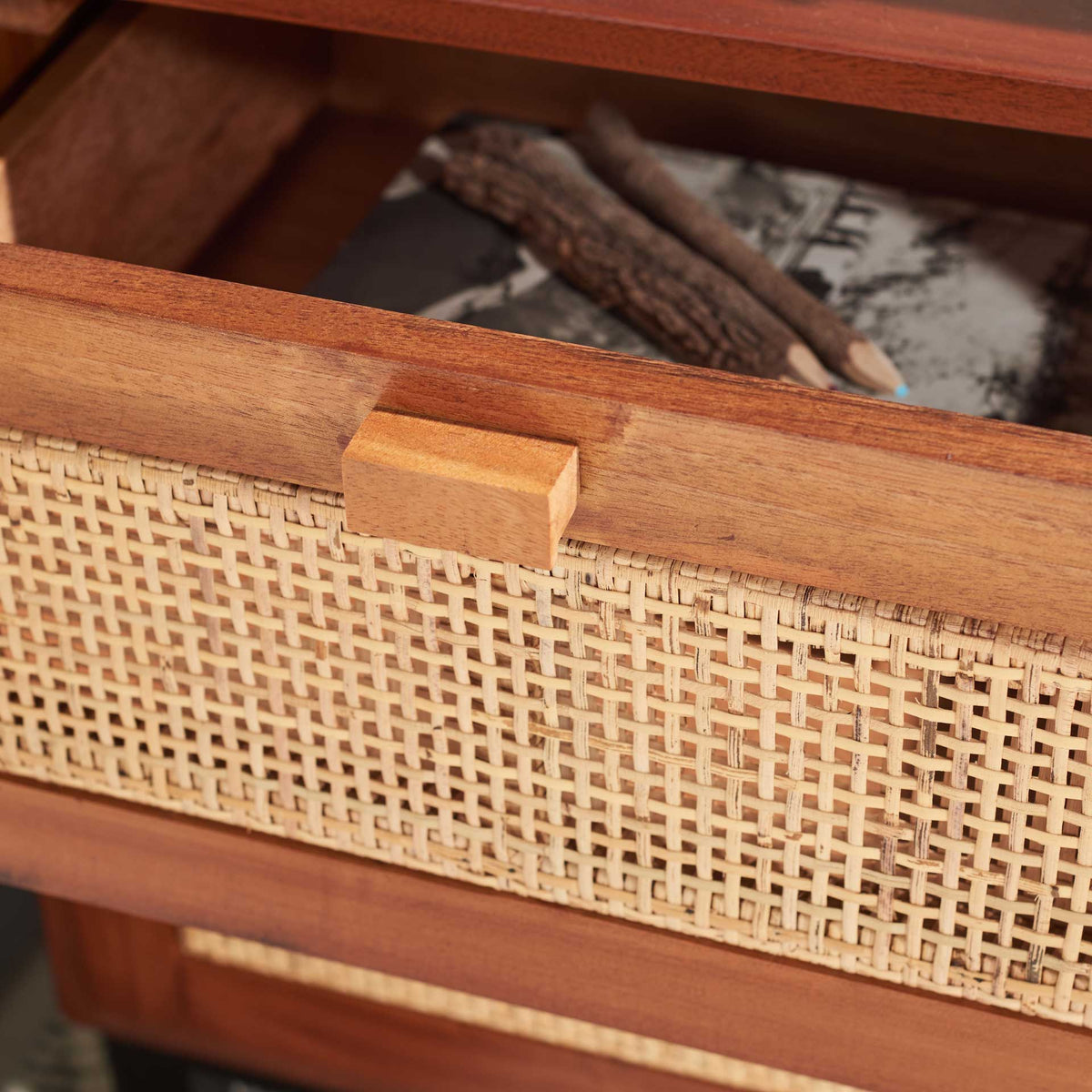 An open cane-front drawer keeps small bedside essentials close at hand.